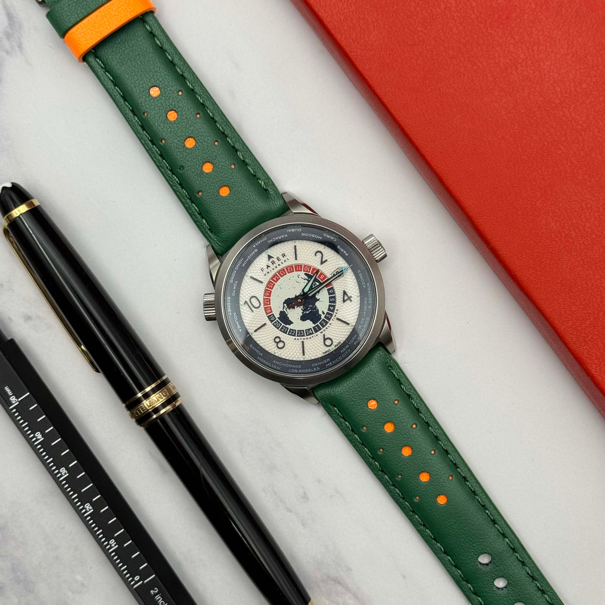 Le Mans Green and orange racing watch strap on the Farer worldtimer. Full grain leather perforated rally strap.