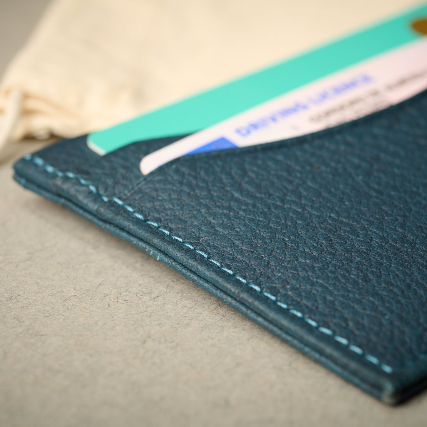 Close up of the Rome blue full grain Italian leather card case. Cards in slots. 5 card slots. RFID blocking technology.