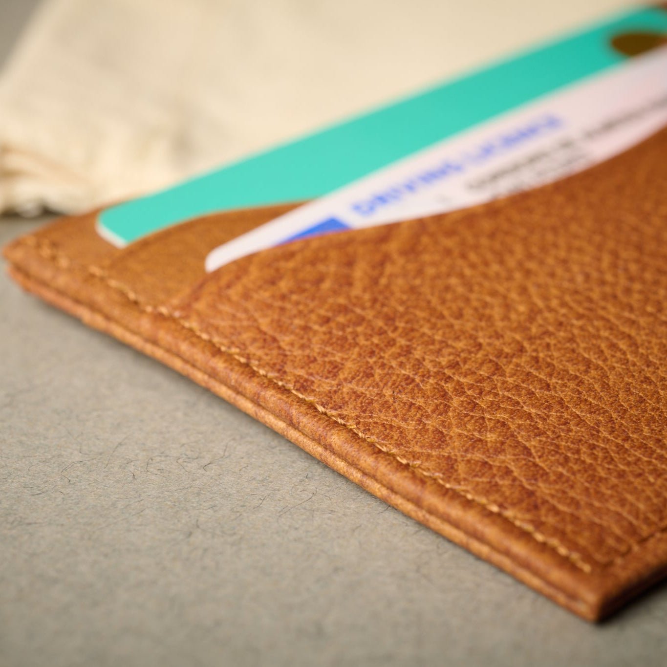 Close up of the Rome Copper Tan Full Grain Italian Leather RFID Blocking Card Case with cards. Grain of the leather.