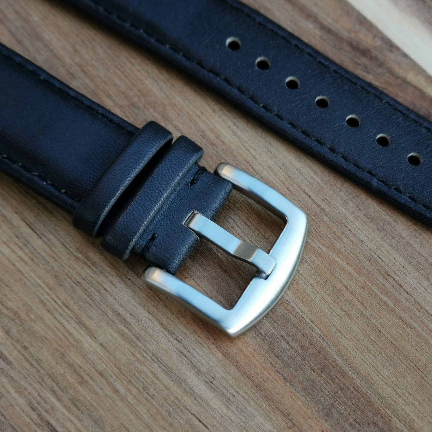 The 316L brushed stainless steel buckle on the Milan black leather apple watch strap. Image also shows the grain of the leather.
