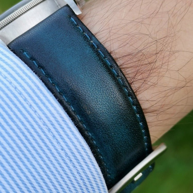 Milan blue vegetable tanned leather apple watch strap placed on a males wrist.