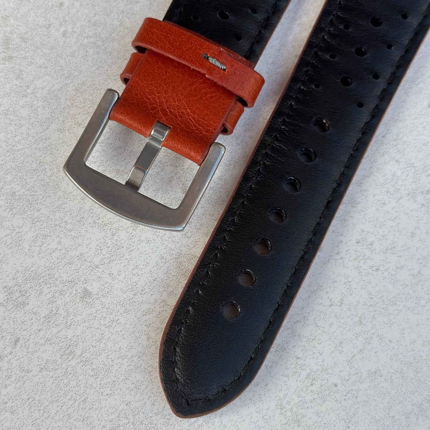 Underside of the brushed 316L stainless steel buckle on the Montecarlo orange perforated leather watch strap. Watch And Strap