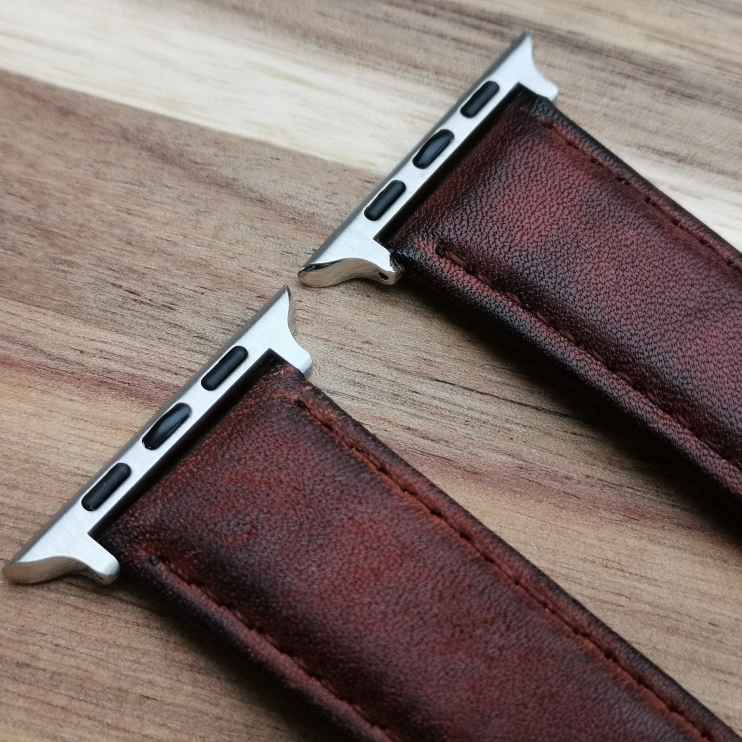 Top of the Milan brown leather apple watch strap. The grain of the faded brown leather and brown stitching.
