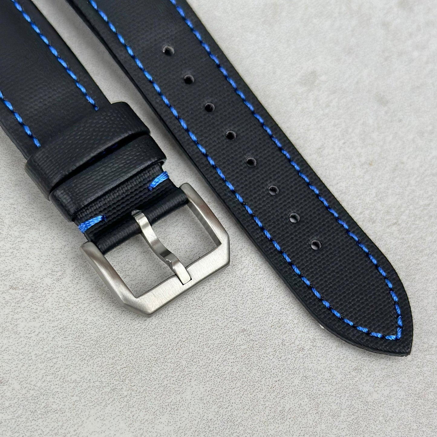 Brushed 316L stainless steel buckle on the jet black sail cloth Apple Watch strap with blue stitching. Watch And Strap