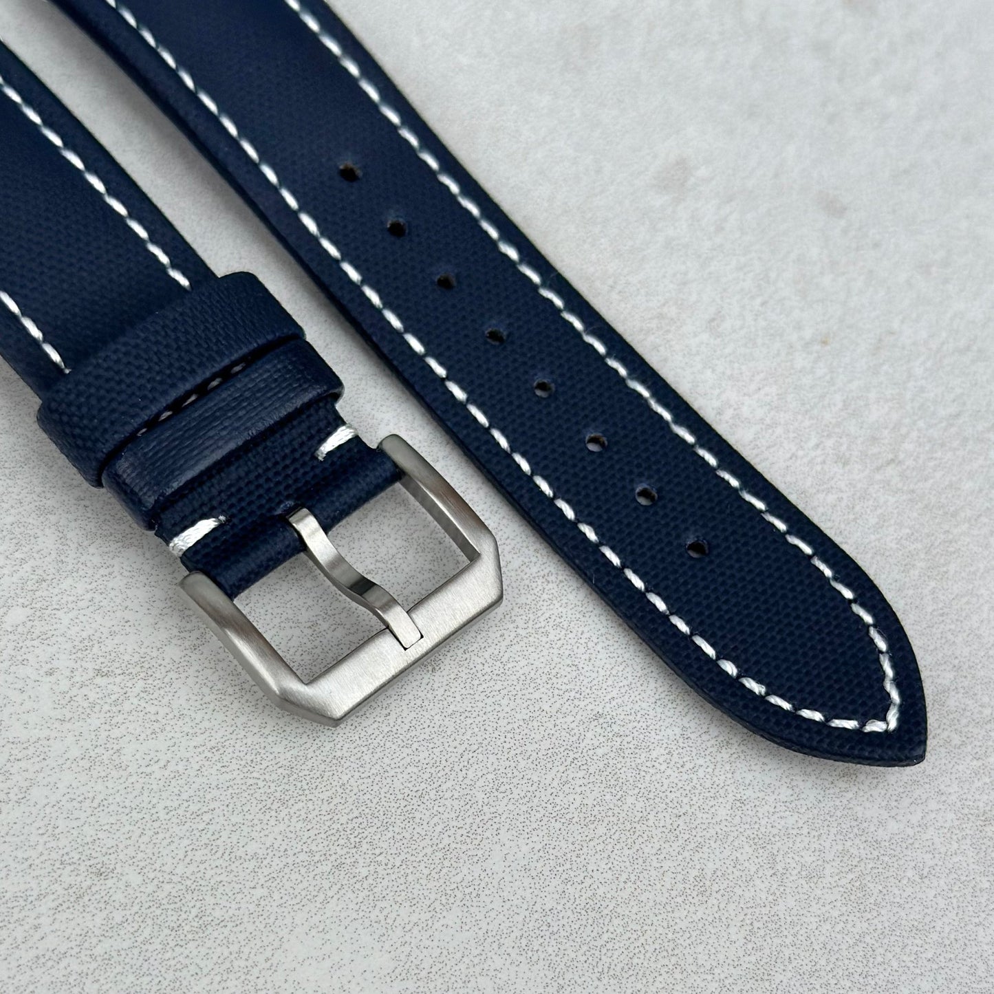 Brushed 316L stainless steel buckle on the navy blue sail cloth Apple Watch strap with white stitching. Watch And Strap