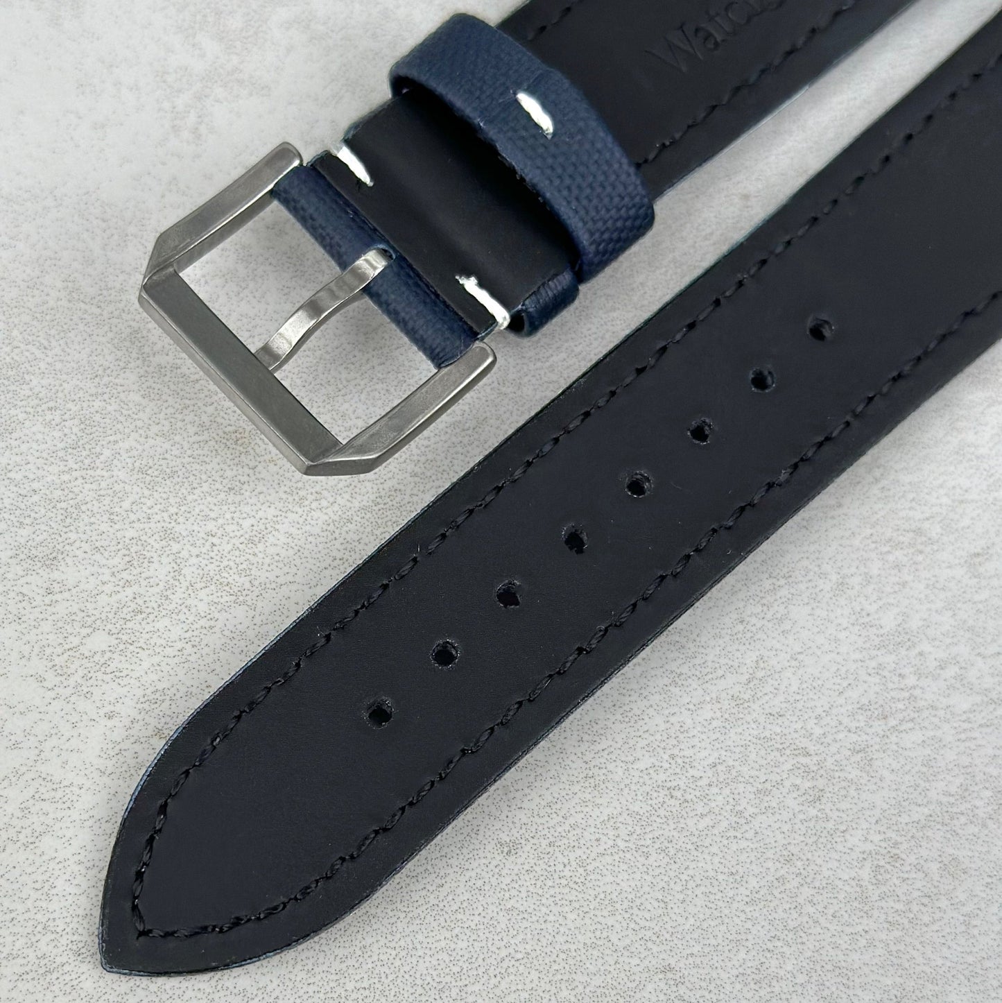 Brushed 316L stainless steel buckle on the navy blue sail cloth Apple Watch strap with white stitching. Watch And Strap
