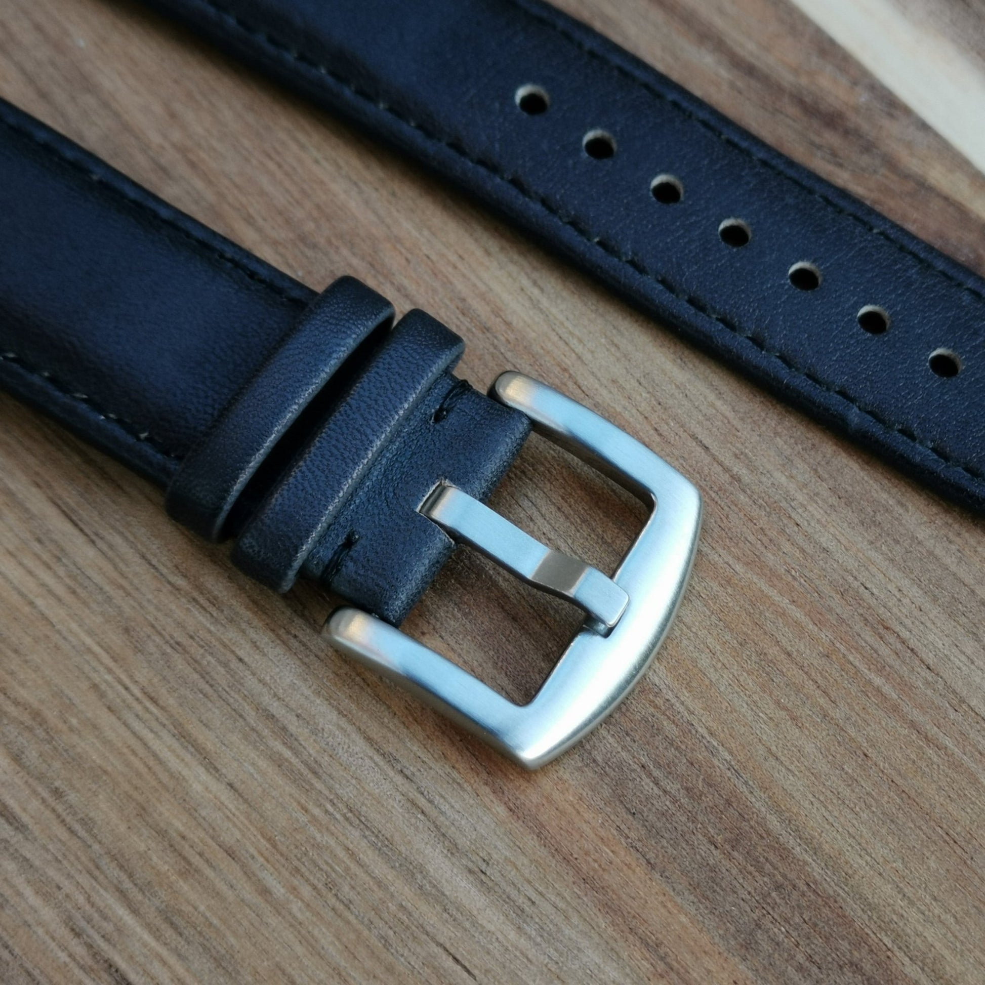 The 316L brushed stainless steel buckle on the Milan black leather apple watch strap. Image also shows the grain of the leather.