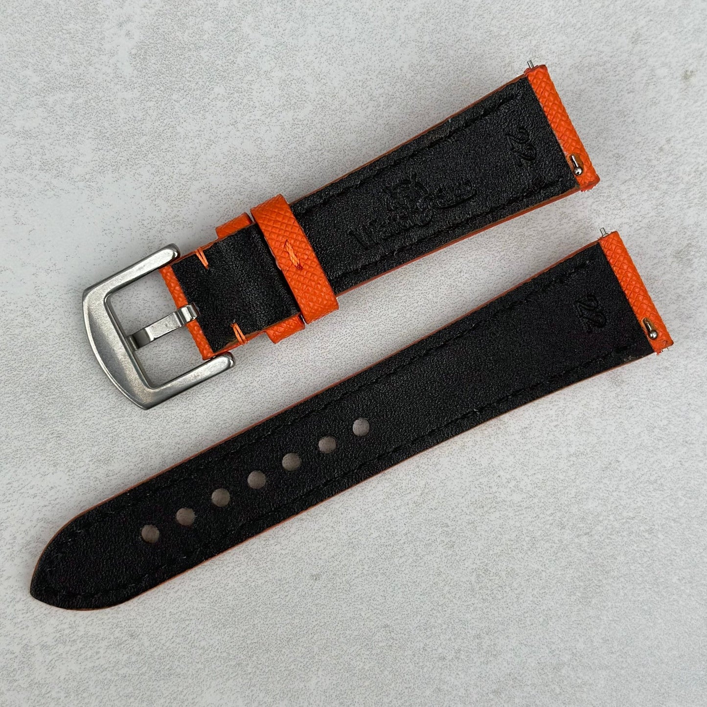 Underside of the Florence orange Saffiano leather watch strap. Watch And Strap logo. Quick release pins.