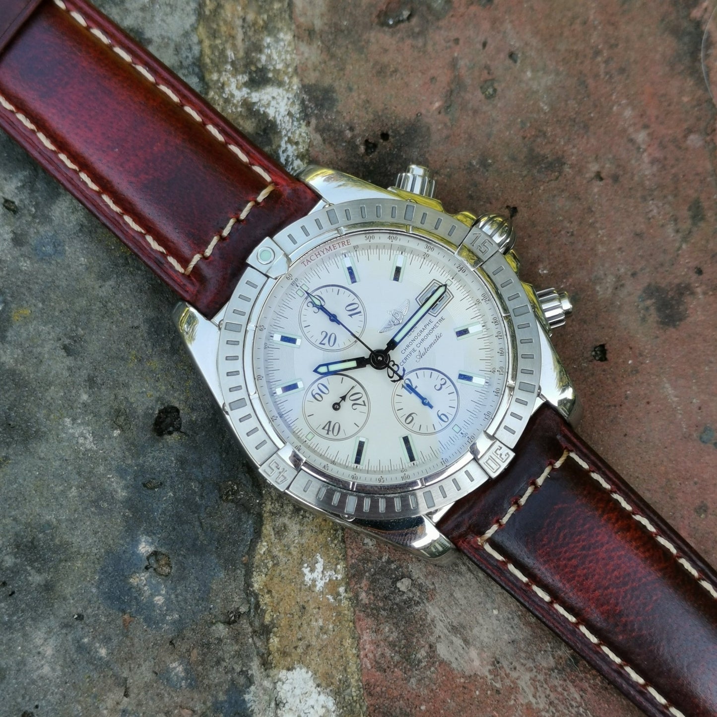 Berlin burgundy full grain leather watch strap. Watch strap placed on a Breitling Evolution Chronomat. Watch And Strap.