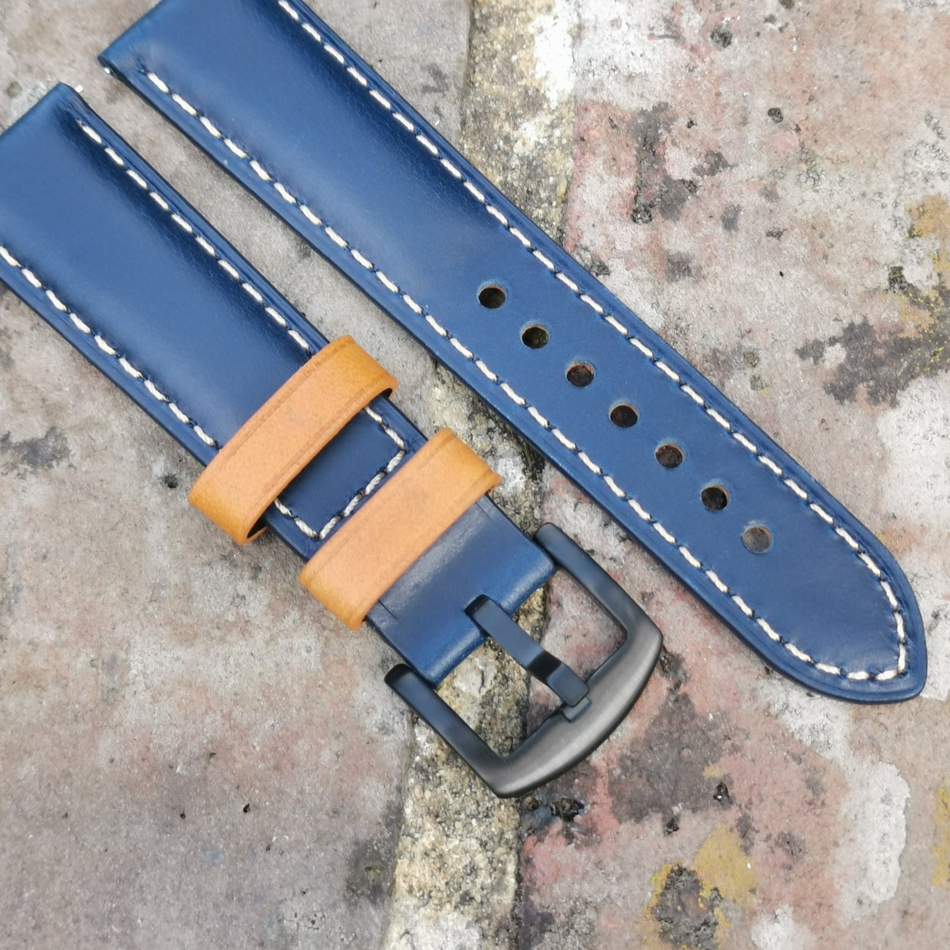 Oxford navy blue full grain leather watch strap fitted with tan loops and a PVD black buckle.